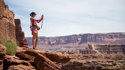 Woman taking a photo from an overlook in Canyonlands National Park