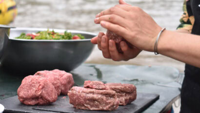 A river guide prepares a bison burger recipe in camp.