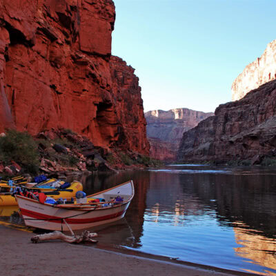 OARS raft and dory moored on a sandy beach in the late afternoon in Grand Canyon