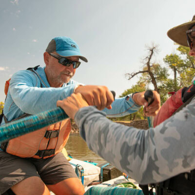 An OARS guide helps a Green River Rowing Clinic guest perfect his oar stroke.