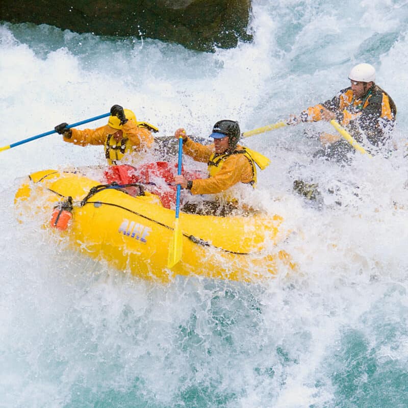 People rafting down a Class V river.