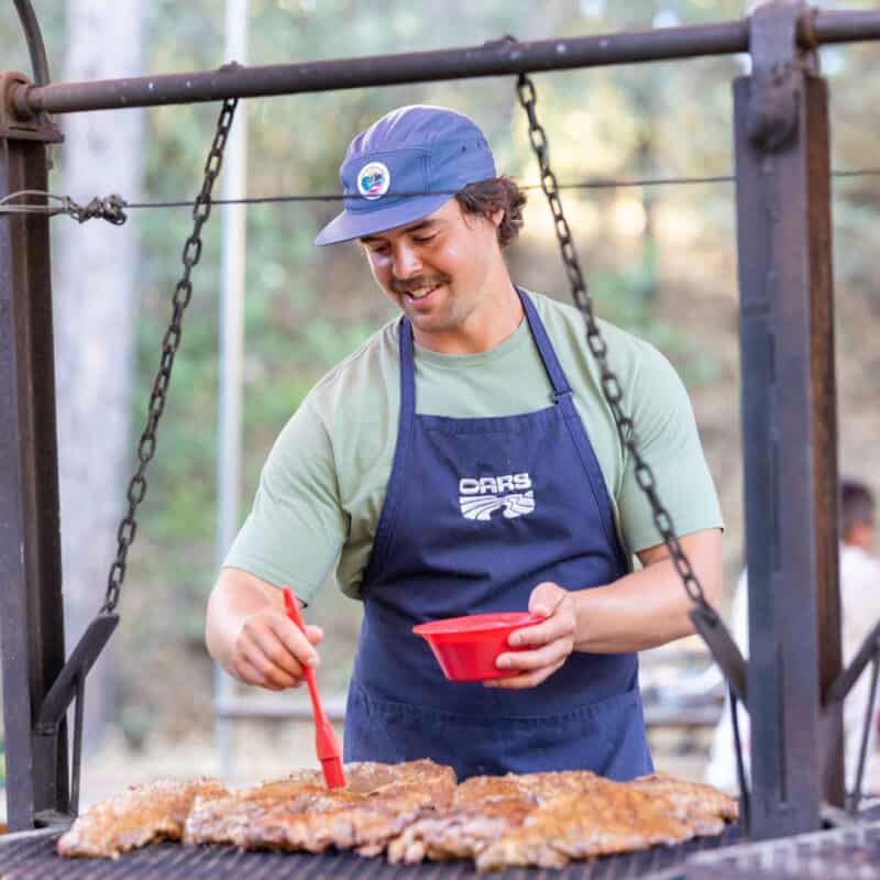 Man cooking on a grill.