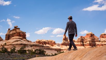 A man walking near The Dollhouse in Canyonlands National Park on an OARS hking trip