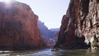 A lone boat floating down the Colorado River on a Grand Canyon rafting trip